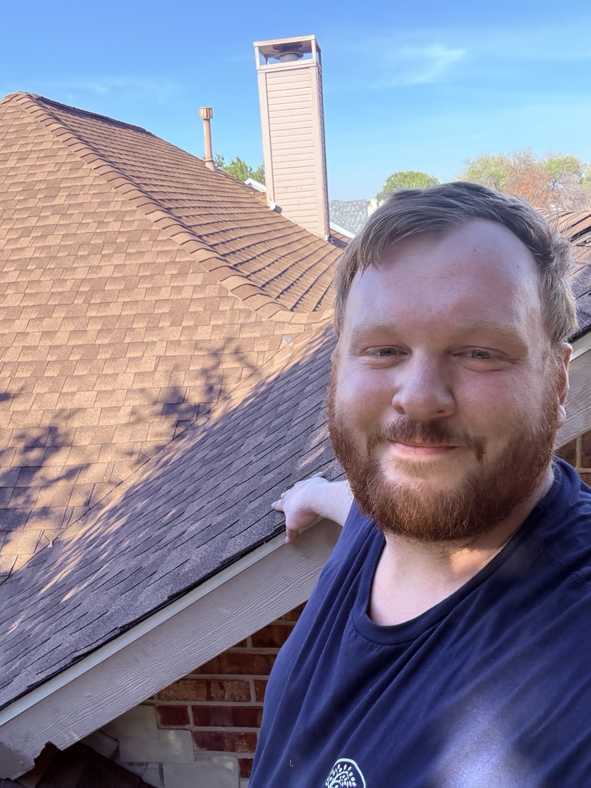 Isaac Pinney on a residential roof during a roofline inspection