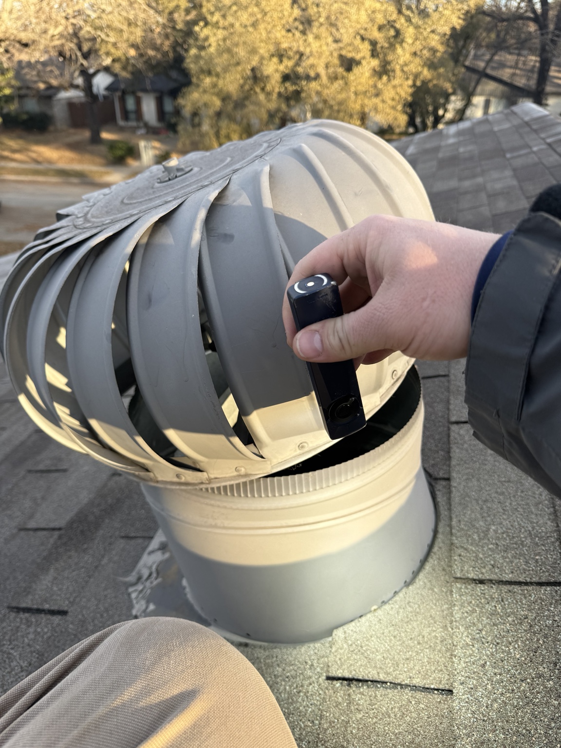 Metal roof vent guard being fitted on a roof